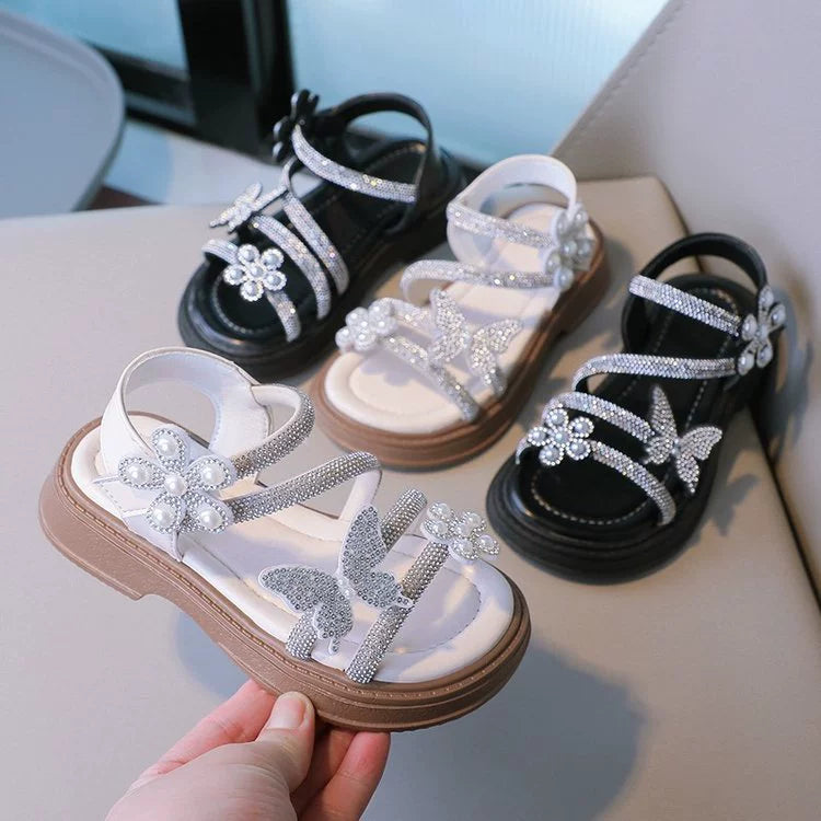Sandalias infantiles con mariposas brillantes.