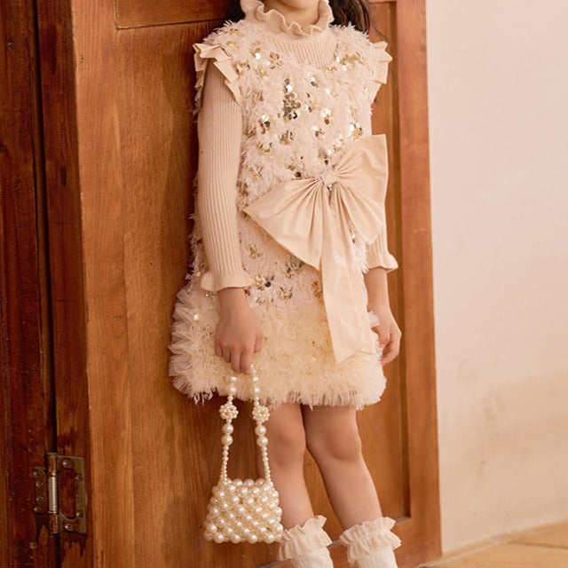 Vestido infantil con lazo brillante.
