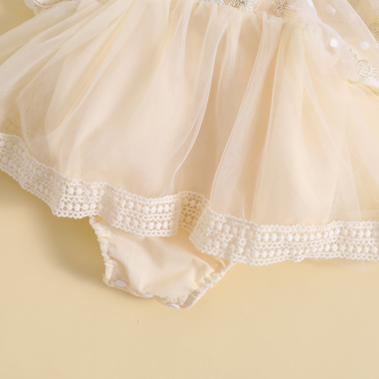 Vestido mameluco, tul con flores bordadas y mangas volantes