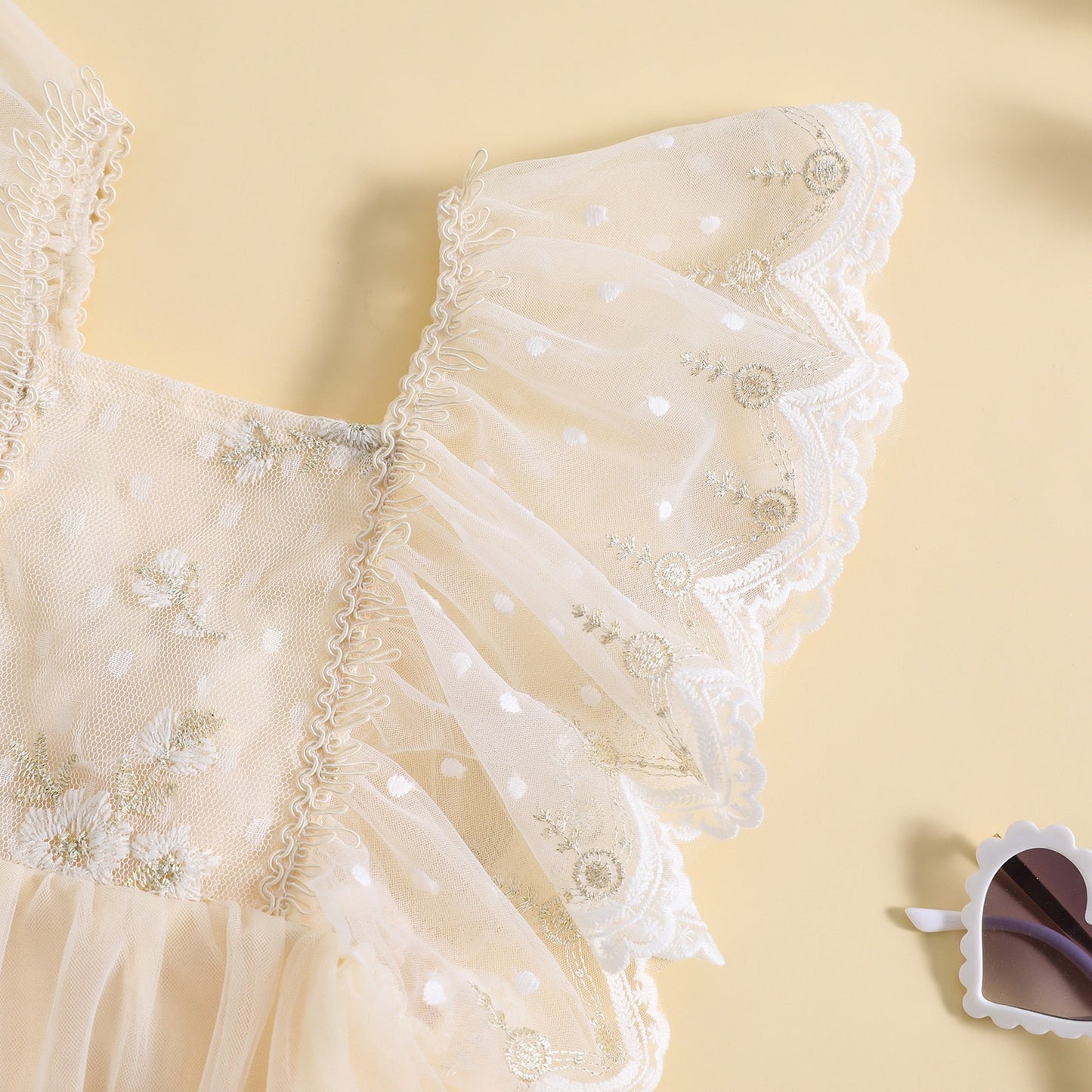 Vestido mameluco, tul con flores bordadas y mangas volantes